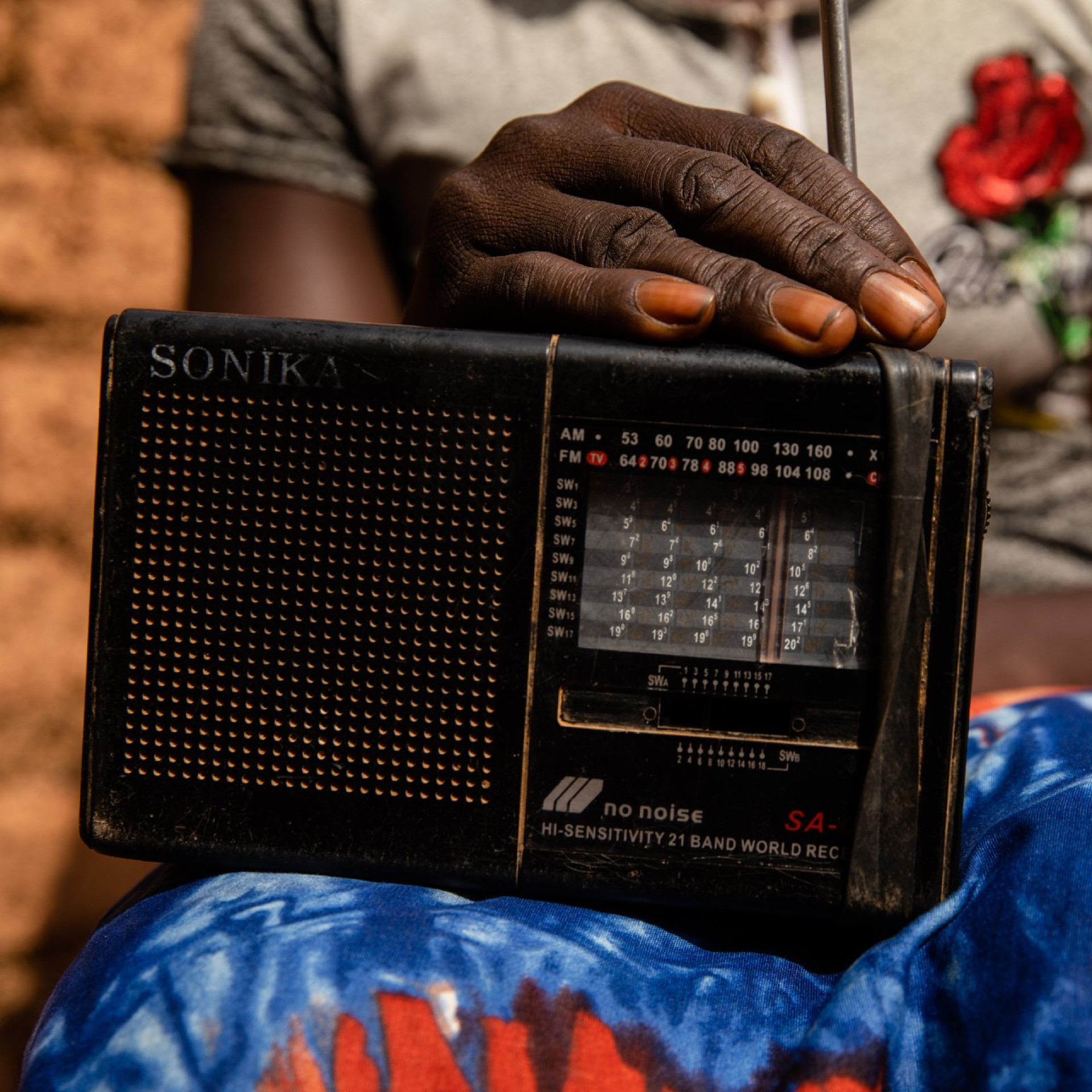 A radio on a woman's lap demonstrating the distribution mechanism used in this campaign
